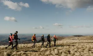 Gruppe beim Wandern in Istrien, mit Blick auf das Meer unter blauem Himmel mit Wolken.