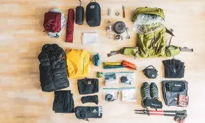 Die Übersicht zeigt eine vollständige **Trekking-Packliste**: Rucksack, Zelt, Schlafsack, Kleidung, Schuhe, Wanderstöcke und Kochutensilien.