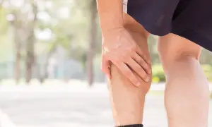 Mann hält sich die Wade, die sich wie ein Pferdekuss anfühlt.
