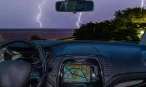 Blick aus dem Auto auf ein Gewitter über dem Meer. Blitze zucken, während man im Auto schläft.
