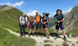 Fünf Wanderer auf der Peter Habeler Runde genießen die Berglandschaft.