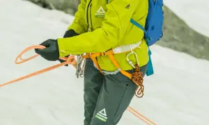 Bergsteigerin bindet mit geübten Händen einen halbmastwurf knoten. Die Seile sind bereit für die nächste Tour.