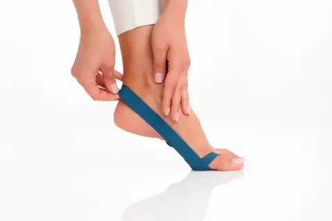 Frau legt blaues Tape am Fuß an. Frage: wie lange tape drauf lassen?