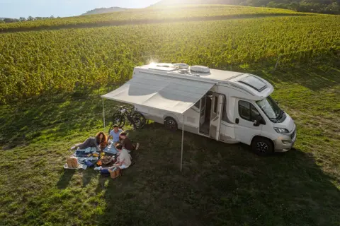 Familie genießt Picknick neben Wohnmobil in Weinbergen. Perfekt für wildcampen Tschechien.
