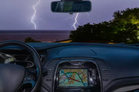 Blick aus dem Auto auf ein Gewitter über dem Meer. Blitze zucken, während man im Auto schläft.