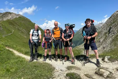 Fünf Wanderer auf der Peter Habeler Runde genießen die Berglandschaft.