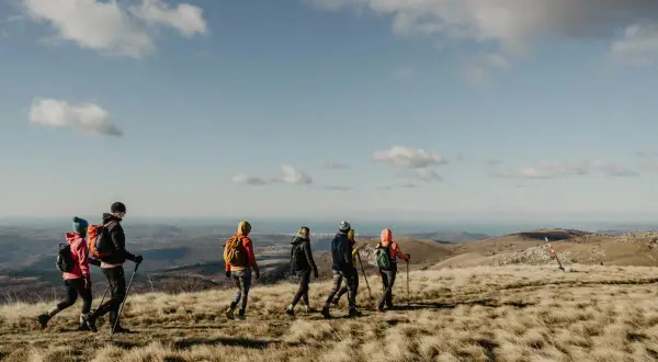 Gruppe beim Wandern in Istrien, mit Blick auf das Meer unter blauem Himmel mit Wolken.