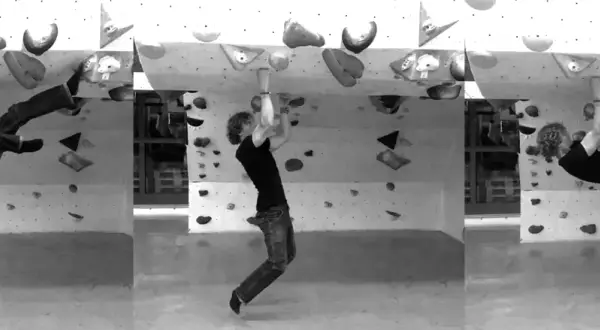 Mann mit lockigem Haar demonstriert verschiedene kletter technik Positionen an einer Boulderwand.