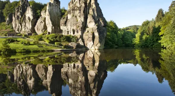 Felsformationen im Teutoburger Wald spiegeln sich in einem ruhigen See.