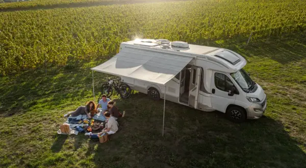 Familie genießt Picknick neben Wohnmobil in Weinbergen. Perfekt für wildcampen Tschechien.