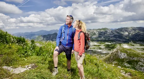 Ein Paar genießt die Aussicht bei Oberstdorf Wanderungen. Die Berge und der Himmel sind atemberaubend.