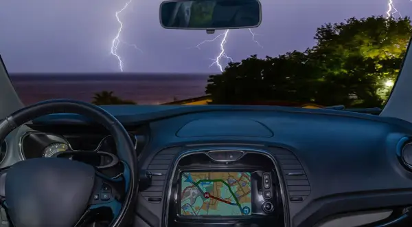 Blick aus dem Auto auf ein Gewitter über dem Meer. Blitze zucken, während man im Auto schläft.