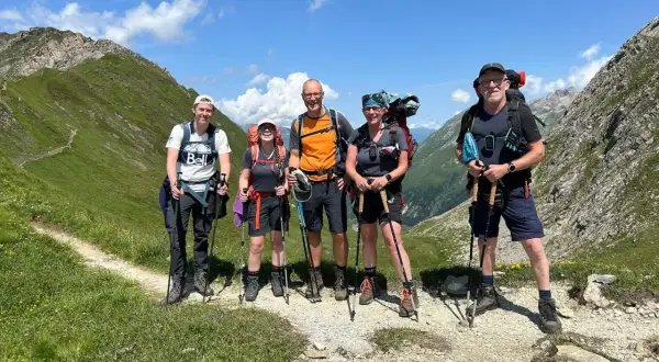 Fünf Wanderer auf der Peter Habeler Runde genießen die Berglandschaft.