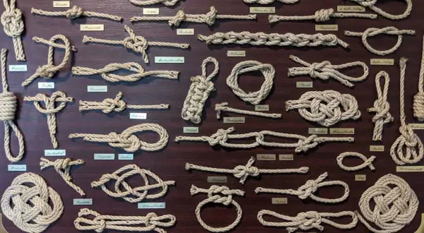 Eine Tafel mit vielen verschiedenen Knoten und ihren Namen. Von einfachen Schlaufen bis zu komplexen Seemannsknoten, hier sind die Knoten Namen zu sehen.