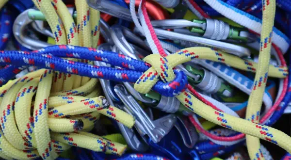 Bunte Kletterseile und Karabiner sind zu einem Gewirr aus Knoten, Knoten und mehr Knoten verheddert.