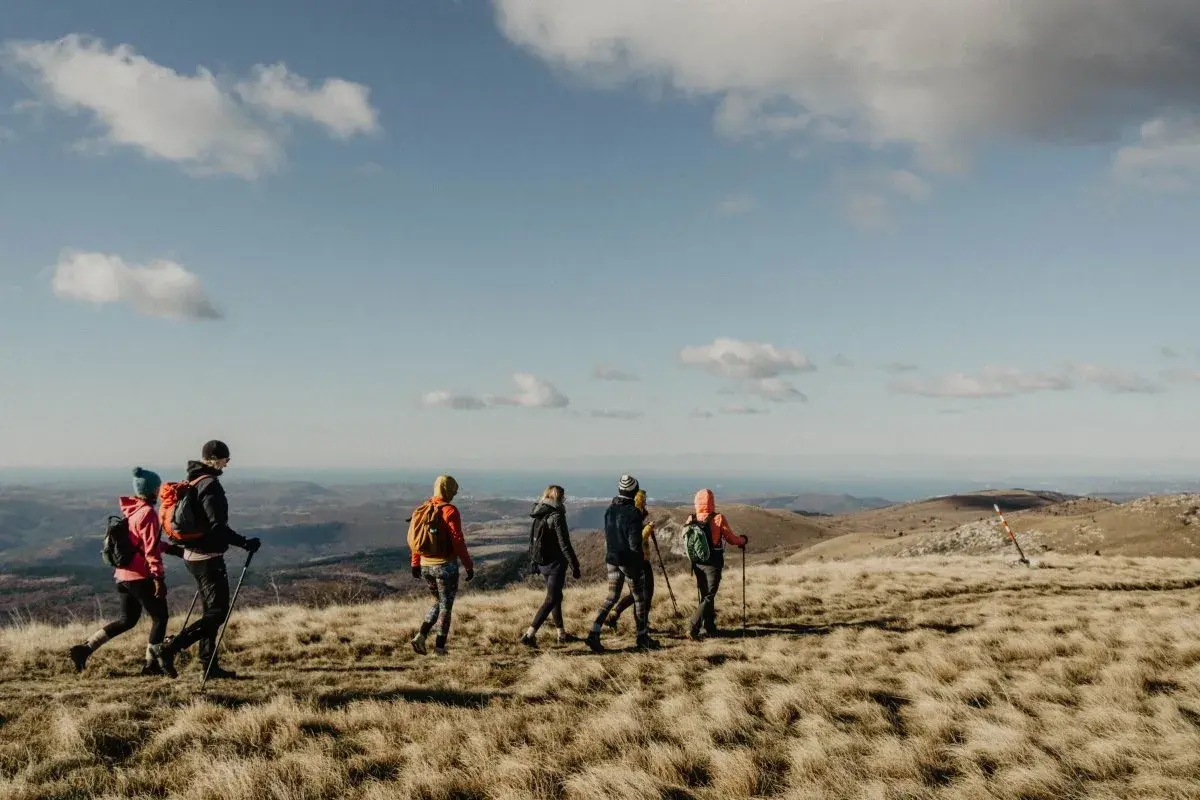 Gruppe beim Wandern in Istrien, mit Blick auf das Meer unter blauem Himmel mit Wolken.