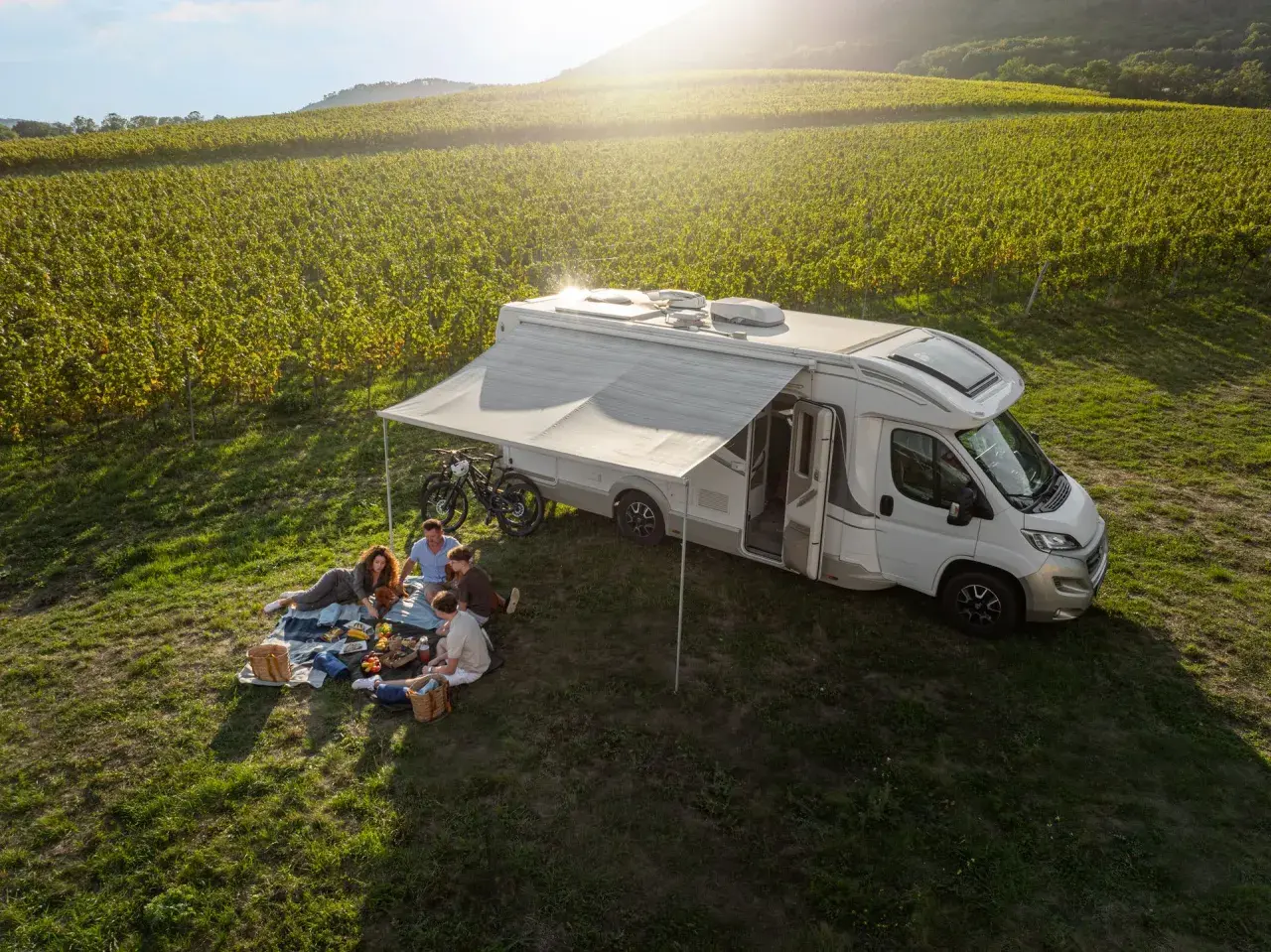 Familie genießt Picknick neben Wohnmobil in Weinbergen. Perfekt für wildcampen Tschechien.