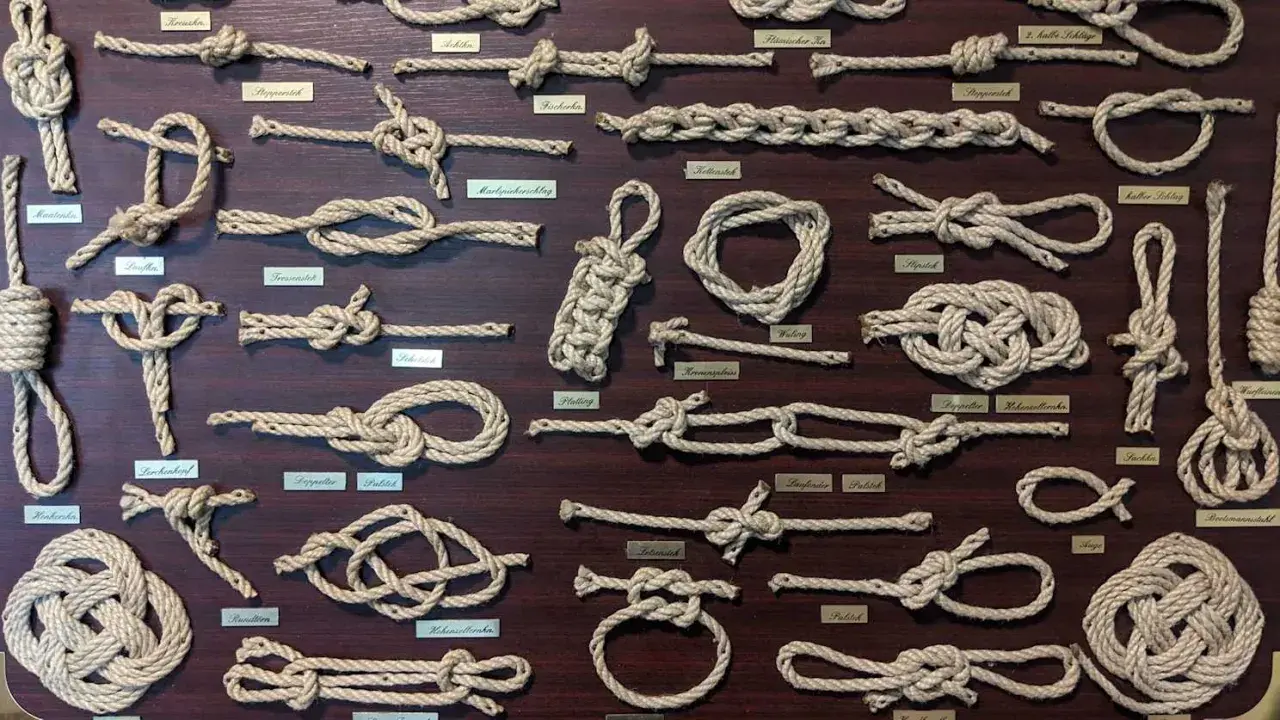 Eine Tafel mit vielen verschiedenen Knoten und ihren Namen. Von einfachen Schlaufen bis zu komplexen Seemannsknoten, hier sind die Knoten Namen zu sehen.