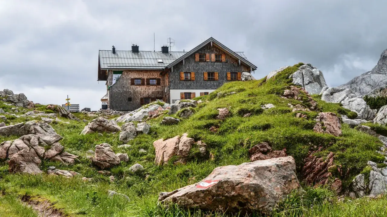 Hütte inmitten eines steinernen Meeres aus Felsen und grünem Gras.