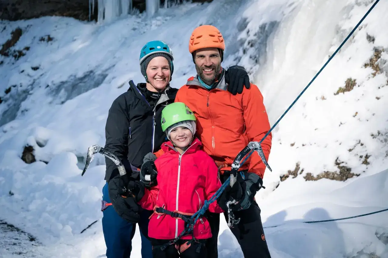 Familie Dettling beim Eisklettern. Sie stehen vor einer Eiswand, bereit für ihr Abenteuer.