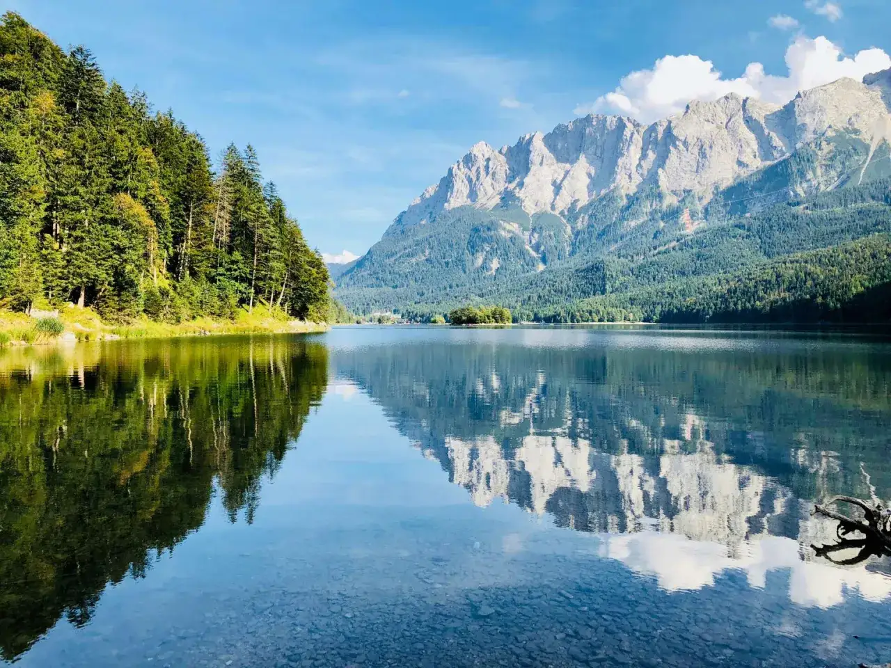 Spiegelglatter See mit Bergpanorama und Wald. Perfekt f&uuml;r eine Wanderung in Garmisch.