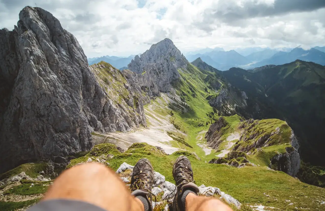 Wanderstiefel blicken auf ein atemberaubendes Panorama im Tannheimer Tal. Entdecke hier echte Geheimtipps f&uuml;r unvergessliche Touren.