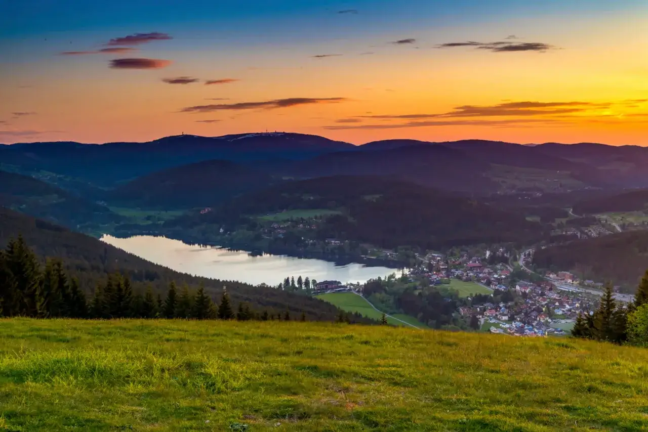 Sonnenuntergang &uuml;ber einem idyllischen Dorf am See im Schwarzwald. Perfekt f&uuml;r eine Schwarzwald Wanderung.