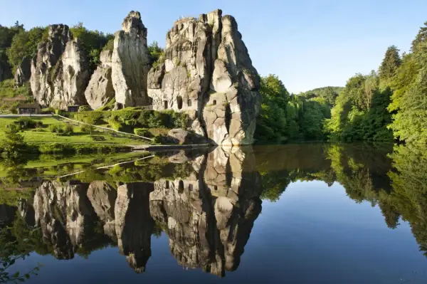 Felsformationen im Teutoburger Wald spiegeln sich in einem ruhigen See.
