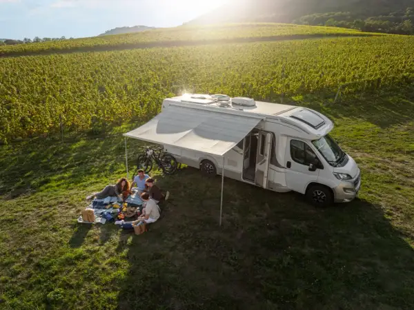 Familie genießt Picknick neben Wohnmobil in Weinbergen. Perfekt für wildcampen Tschechien.