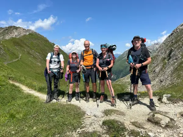 Fünf Wanderer auf der Peter Habeler Runde genießen die Berglandschaft.