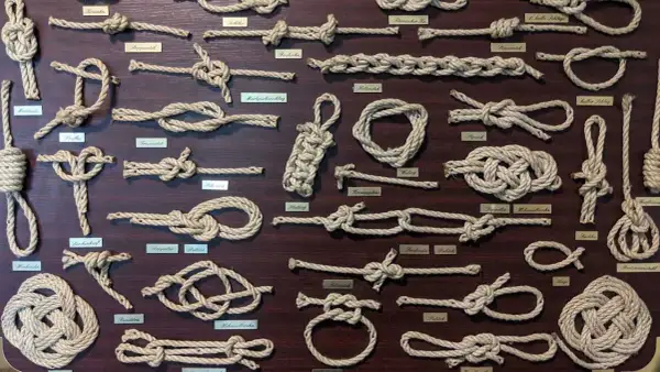 Eine Tafel mit vielen verschiedenen Knoten und ihren Namen. Von einfachen Schlaufen bis zu komplexen Seemannsknoten, hier sind die Knoten Namen zu sehen.