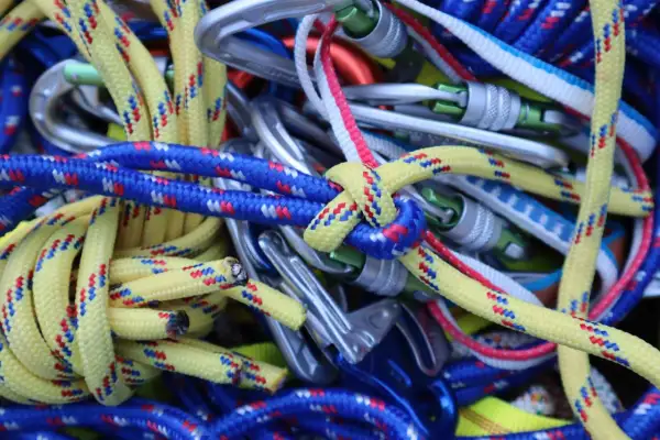 Bunte Kletterseile und Karabiner sind zu einem Gewirr aus Knoten, Knoten und mehr Knoten verheddert.